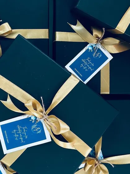 A top-down view of the favor boxes, highlighting the elegant gold ribbons and personalized tags.
