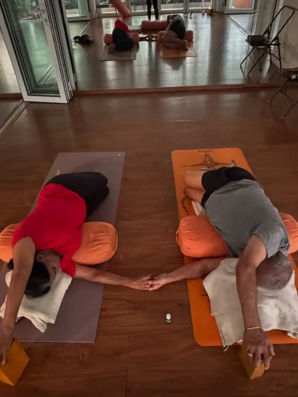 A closer look at the connection between two practitioners in a restorative twist. It’s a beautiful example of finding peace and support together on the mat.