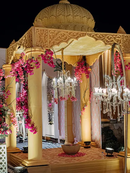 A close-up of a smaller mandap-style structure, adorned with pink flowers and a crystal chandelier. This space provides an intimate and beautiful setting for smaller rituals or photo opportunities.