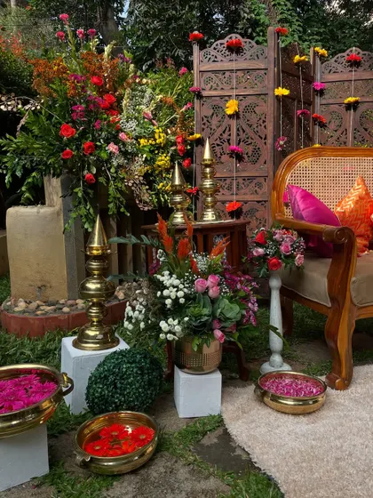 A close-up of the floral and brass decor at a Mehandi ceremony. The combination of vibrant flowers and traditional elements creates a rich and celebratory look.