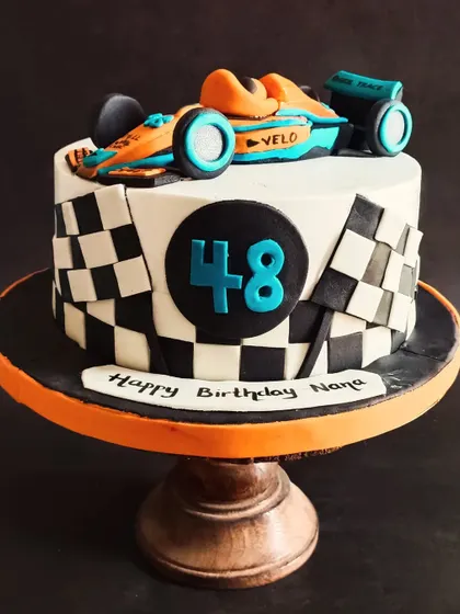 A sleek McLaren Formula 1 car cake for a racing fan's 48th birthday.