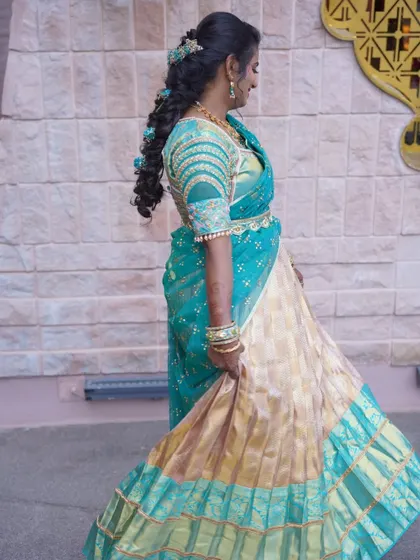 A full-length shot of Tharuna twirling in her beautiful half saree. The pleated gold skirt has a beautiful flow.