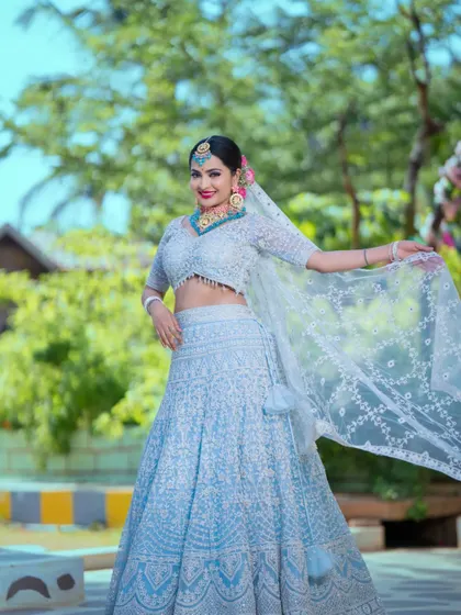A full-length shot capturing the graceful flow of the lehenga and veil, showcasing the complete bridal ensemble.