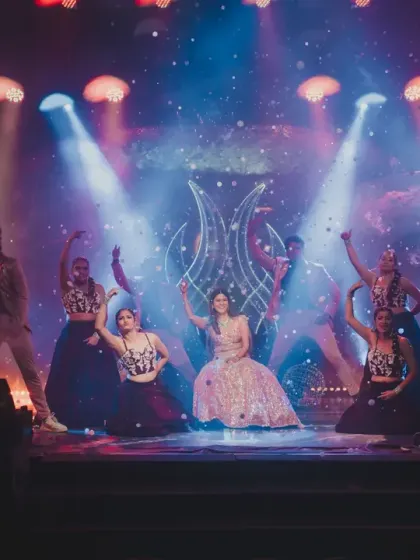 The bride and her backup dancers in a powerful pose, with the stage lighting and cosmic backdrop creating a stunning visual.