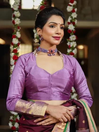 This model pairs a lavender silk blouse with a stunning blue stone choker, creating a cool-toned, regal look.