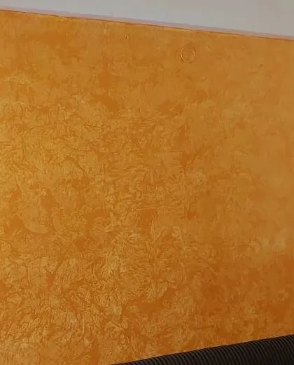 A warm, orange-hued wall with a subtle, sponge-applied texture, adding a cozy and inviting feel to the room.