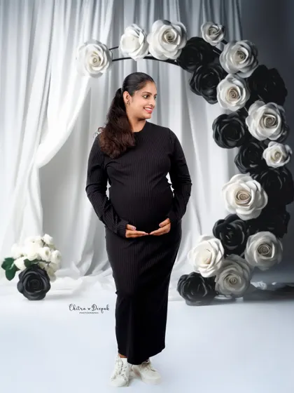 A modern and chic black-and-white theme. The simple black dress and the paper flower arch create a sophisticated and artistic look.