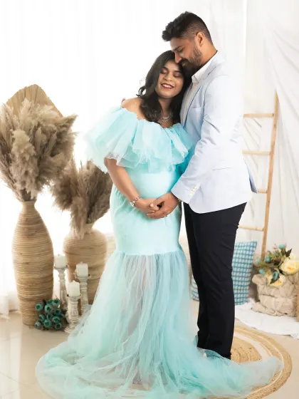A beautiful, heartfelt embrace. The couple holds hands over the baby bump, a perfect symbol of their partnership on this incredible journey.