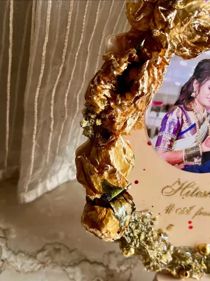A close-up of a photo frame with 3D preserved golden roses. This custom frame is a beautiful way to showcase wedding flowers and add texture to your keepsake.
