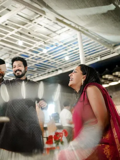 A motion-blur shot capturing the fun and laughter of guests dancing at a reception.