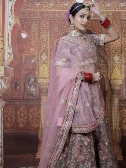 A model wearing a beautiful floral printed lehenga in a mauve-pink shade. This is a light and elegant option for a day wedding or a bridesmaid.