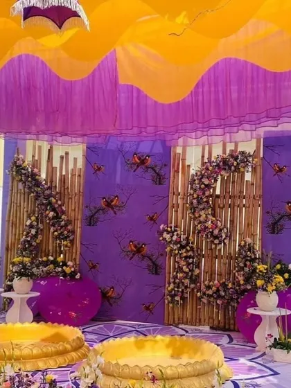 The main stage for a Haldi ceremony with a unique purple and yellow theme. The backdrop features butterfly motifs and traditional seating arrangements.