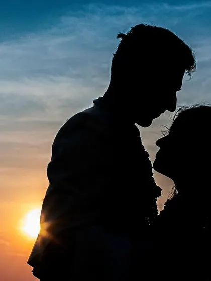 A dramatic sunset silhouette. This artistic shot captures the couple's profiles against a fiery sky, creating a powerful and romantic image.