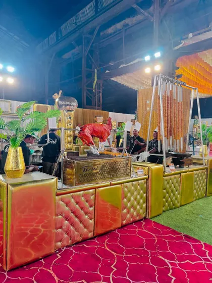 Our striking red and gold themed barbecue counter, featuring a whole roasted chicken and hanging seekh kebabs.