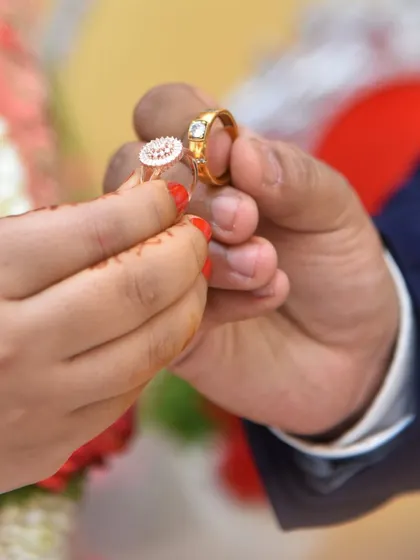 A close-up of the couple exchanging rings during their engagement ceremony.