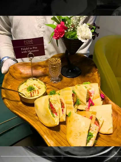 A platter of freshly made Falafel in Pita with Hummus. This classic Middle Eastern dish is a healthy and flavorful option for any corporate event, presented beautifully on a wooden tray.