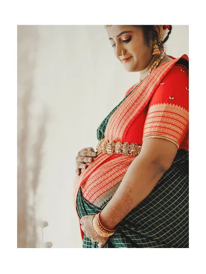 This side profile beautifully showcases the baby bump and the traditional attire. The makeup is subtle, ensuring the focus remains on the mother-to-be's happiness.