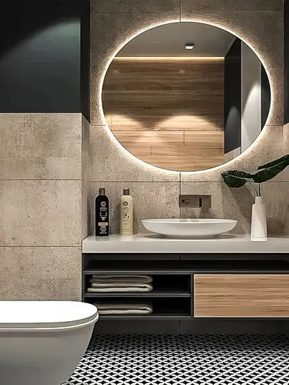 This modern bathroom design features a floating vanity, a vessel sink, and a large, backlit circular mirror that creates a dramatic focal point. The combination of concrete-finish tiles, patterned flooring, and warm wood accents gives the space a contemporary yet inviting feel.