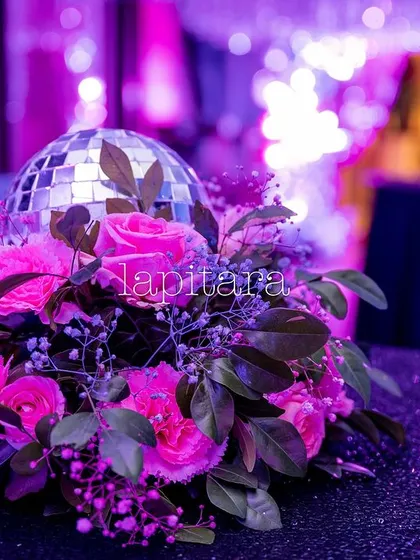 An elegant-yet-fun table centerpiece, combining a fresh pink floral arrangement with a miniature disco ball.