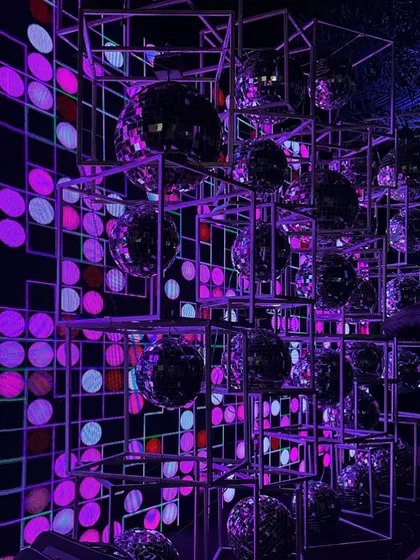 A geometric installation of disco balls for a retro-themed party. We arranged mirror balls within metal cubes against a pixelated LED screen to create a multi-dimensional and dazzling photo opportunity.