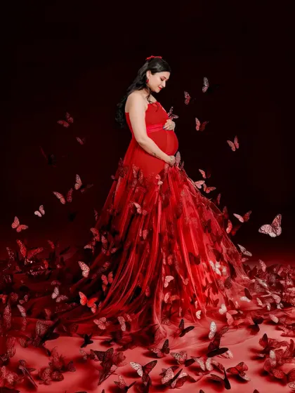 A truly magical shot created with thoughtful editing. The mom-to-be stands in a beautiful red gown as a swirl of red butterflies surrounds her, creating a fairytale moment.