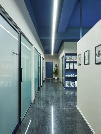 Another view of the clinic's corridor, showing how the modern lighting and reflective floors create a bright and welcoming atmosphere.