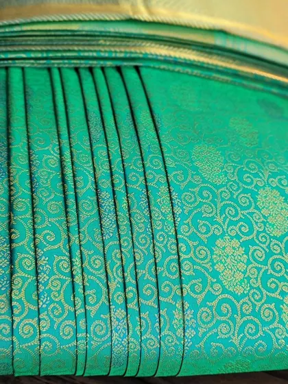 A detailed shot of the pleats on the turquoise saree.