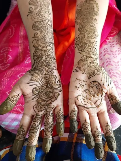 The full view of an Arabic-style baby shower mehendi. The design flows from the fingers up the arm, leaving some skin exposed for an elegant and contemporary look, while still including a personal touch on the palm.