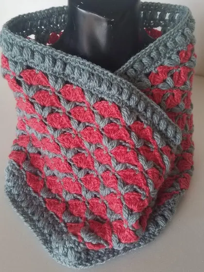 The pink and grey version of the Cardamom Blossoms cowl on display. The stitch definition is excellent, creating a beautiful and highly textured accessory.