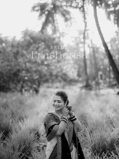 A beautiful black and white portrait of the bride adjusting her earring in a natural, sunlit setting.