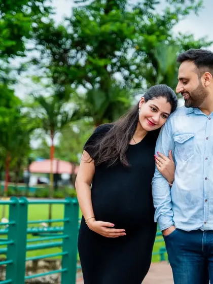 A quiet walk in the park. The mother-to-be rests her head on her partner's shoulder, a simple gesture that conveys so much love and trust in this candid maternity portrait.