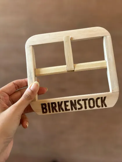 A sneak peek of the project: the custom-engraved wooden buckle before it was painted. Every component of this installation was carefully crafted.