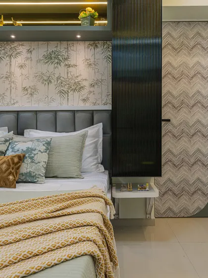 A close-up showing the textures in the bedroom. The tufted headboard, the fluted panel, the patterned cushions, and the soft throw all work together to create a rich, layered look.
