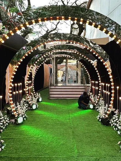To create a glamorous and high-energy entrance for a Sangeet night, I used a series of arched mirror panels lined with retro-style bulbs. This creates a stunning tunnel of light and reflections that sets a celebratory mood from the moment guests arrive. The design is modern, chic, and perfect for an evening of music and dance.