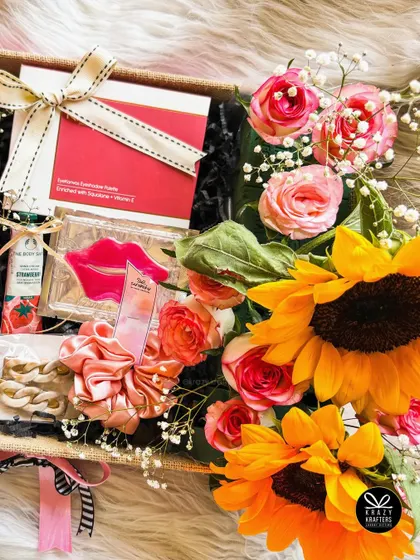 A beautiful shot of our sunflower and rose birthday hamper, showing the fresh flowers alongside the curated gifts.