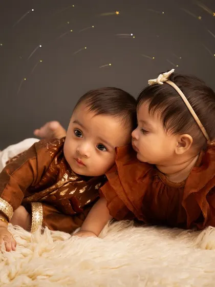 A secret between cousins. This adorable portrait captures a special moment between two baby cousins who were born on the same day, highlighting their budding friendship.