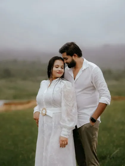 A gentle, intimate portrait taken during a misty morning shoot. The soft light and foggy background create a serene and romantic setting, focusing purely on the couple's connection.