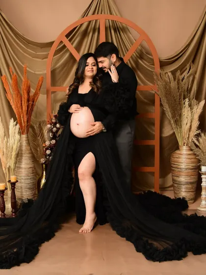 A dramatic and romantic couple's portrait featuring a gorgeous black ruffled gown. We posed the couple against our earthy, boho-inspired backdrop with pampas grass to create a moody yet intimate pregnancy photograph.