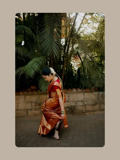 An artistic shot of the bride in a beautiful silk saree, walking along a stone path.