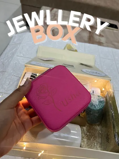 This vibrant pink jewellery box was customized with the name "Usha" and a delicate rose line art design. It's shown here as part of a larger gift hamper, demonstrating how my items can be bundled for a special present.