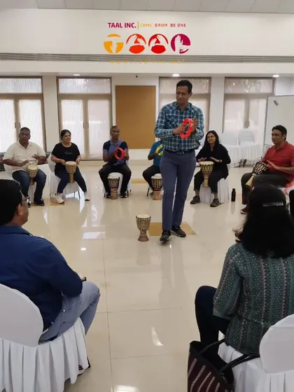 I am demonstrating a rhythm on a tambourine during a leadership workshop. We use a variety of percussion instruments to show how different roles and voices can come together to create a harmonious whole.