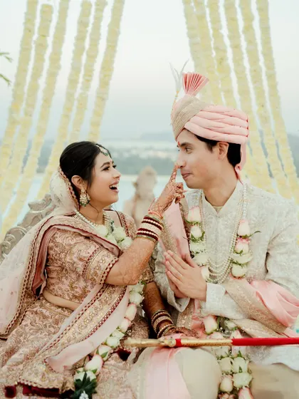 A playful and candid moment during the wedding ceremony. The bride lovingly teases the groom, showcasing their comfortable and joyous connection even during the formal rituals.