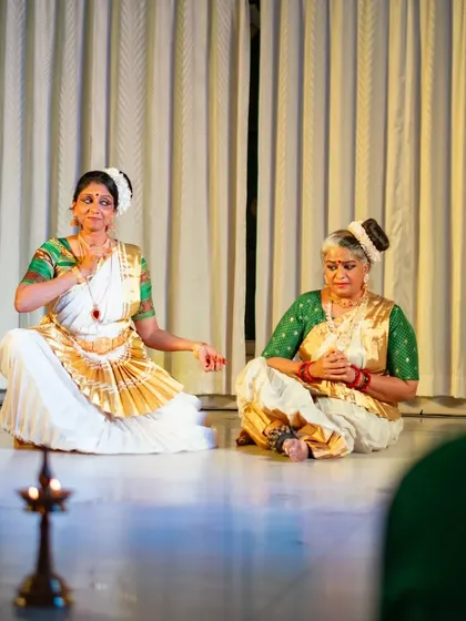 A seated scene from "Uthara," performed in an intimate setting with a traditional lamp, creating a unique atmosphere.