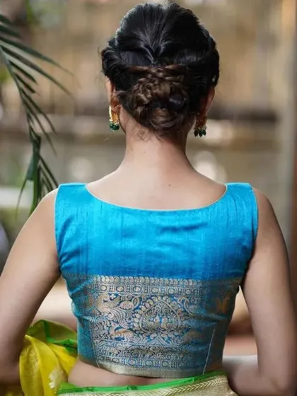 A back view of our bright blue blouse with a wide brocade panel, perfect for pairing with a contrasting yellow saree.