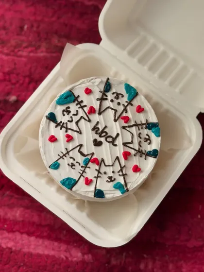 This bento cake is covered in cuteness with a pattern of cartoon cat faces and little red hearts. A simple "hbd" in the middle makes it a purr-fect birthday treat.