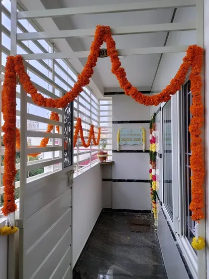 Simple marigold garlands decorating a balcony railing and window.