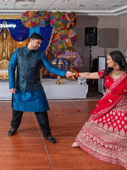 The couple's sangeet dance, full of coordinated moves and playful energy, set against a vibrant, colorful backdrop.