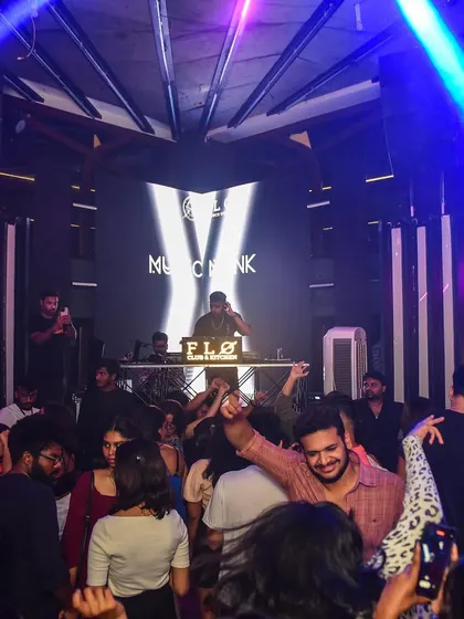 A wide shot of the party at Flo, with me at the helm. The blue lighting creates a cool, electric atmosphere.