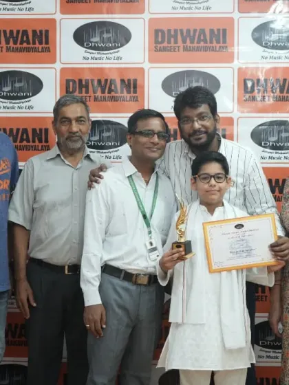 A family celebrates their son's musical achievement with his teachers.
