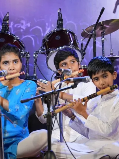 A trio of young flautists playing in harmony, a result of dedicated group practice sessions.